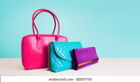 3 colorful fashion bags purses isolated on light blue background.  - Shutterstock ID 382057750