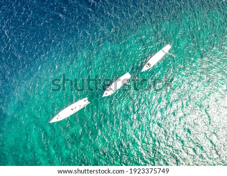 3 kapal nelayan tradisional sedang mengarungi laut bali yang indah