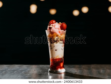 3 layered falooda with ice cream, cherry and strawberry on top 