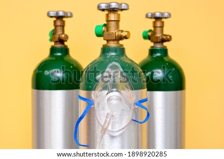 3 Medical Oxygen Tanks with Oxygen Mask on One of Them