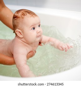 3 Month Baby Swimming In The Bath In Mothers Hands