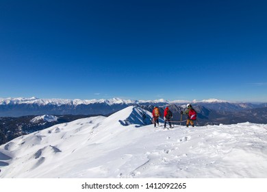 3 Mountain Climbers Walk On Snow In The Mountains