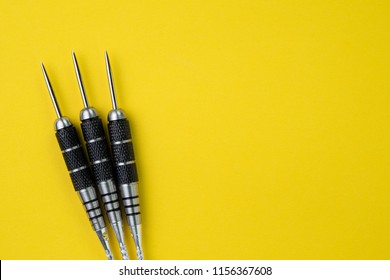 3 Perfect Black Darts Flat Lay On Solid Yellow Background With Copy Space Using As Target And Goals Or Three Best Important Things You Need To Know Concept.