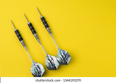 3 Perfect Black Darts Flat Lay On Solid Yellow Background With Copy Space Using As Target And Goals Or Three Best Important Things You Need To Know Concept.