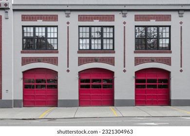 3 red garage doors at a modern fire station in downtown Seattle with red brick highlights