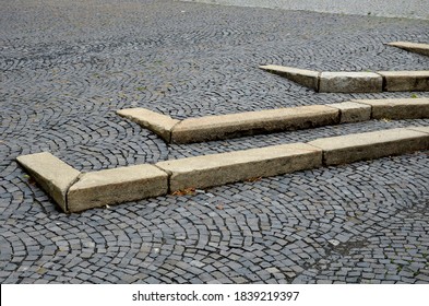 3 Rows Of Stairs In The Square Are Gradually Sunk Into The Paving. Slow Transition Of The Staircase To The Plane By Blending, Intersecting The Granite And Marble At The Entrance To The Building