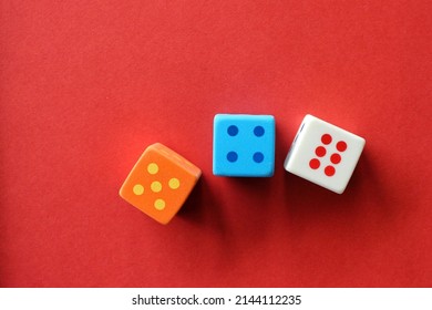 3 rubber dices on a red paper background.