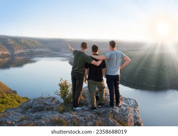 3 rural sport young adult boy guy cheer joy fun hug rest relax behind rear view life light sun text space. Glad woman stand hand arm show peace sea fog climb top camp high stone cliff peak field scene