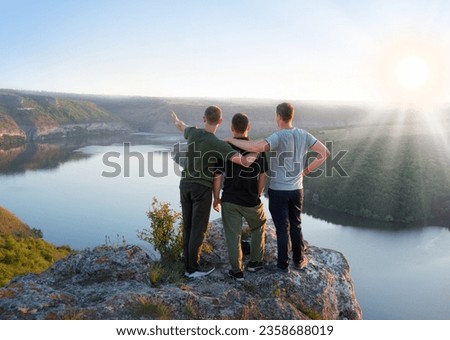 3 rural sport young adult boy guy cheer joy fun hug rest relax behind rear view life light sun text space. Glad woman stand hand arm show peace sea fog climb top camp high stone cliff peak field scene
