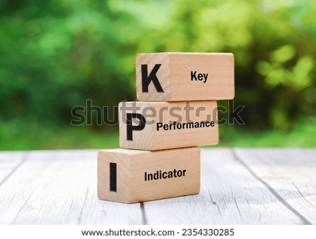 3 stacking rectangle wooden cubes on wooden table with KPI text short for Key Performance Indicators on green natural environment background.Financial business concept.