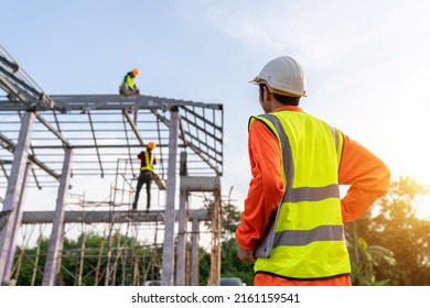 3 Workers in Construction Site, Engineer technician watching team of Workers Steel roof structure under construction. Teamwork Concept.