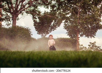 3 year old boy playing in the sprinklers on a hot day -- image taken outdoors in Reno, Nevada, USA