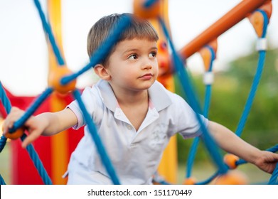 3 Year Old Kid In A Playground Outdoor. 