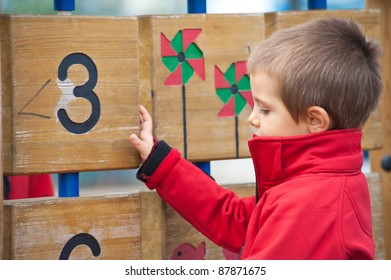 3 Year Old Kid In A Playground Outdoor.