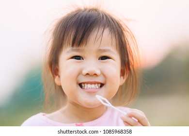 3 years old kid smiles widely and show her teeth : Close up picture.