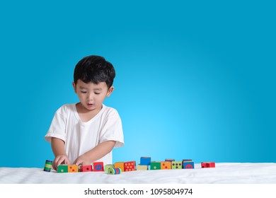 3 Years Old Little Cute Asian Boy Play Toy Or Square Block Puzzle At Home On The Bed, Kid Lying Learn By Playing Block Shape Or Pieces, Education And Healthy Concept.