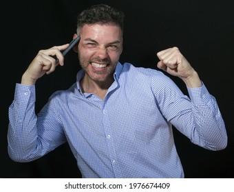30 To 40 Year Old Man In Black Shirt On Black Background Talking On The Phone Smiling At The Camera With Positive And Triumphant Attitude.