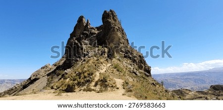 30 April 2023. Dramatic view of Muela del Diablo (“Devil’s Molar”) near La Paz at an elevation of 3,852 meters, featuring rugged sandstone spires and eroded formations rising above the Andean landscape, with panoramic views of the surrounding mountains and the city below under clear blue skies.