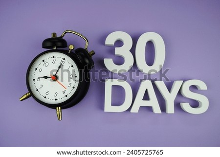30 Days alphabet letters with alarm clock top view on purple background, business and education concept background