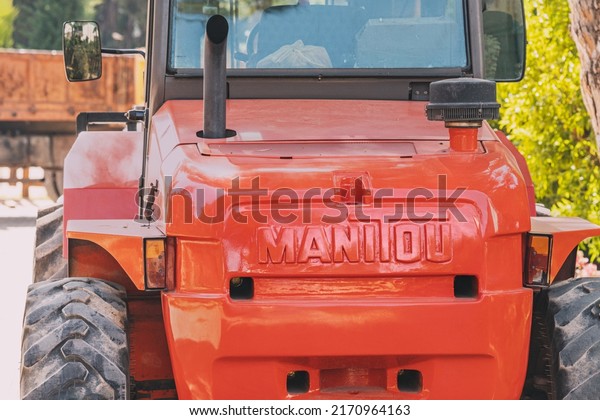30 May\
2022, Antalya, Turkey: French company Manitou logo on a body of a\
red powerful tractor or bulldozer wtih\
forklift
