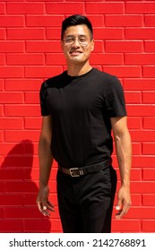 30 Year Old Latin Man In Black Clothes And Glasses On Red Brick Background