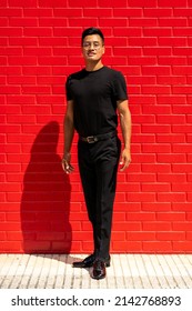 30 Year Old Latin Man In Black Clothes And Glasses On Red Brick Background