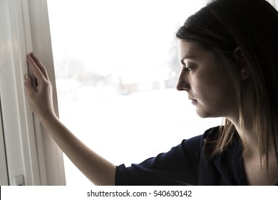 A 30 Year Old Woman Stands In Front Of The Window