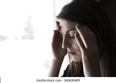 A 30 Year Old Woman Stands In Front Of The Window