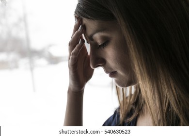 A 30 Year Old Woman Stands In Front Of The Window