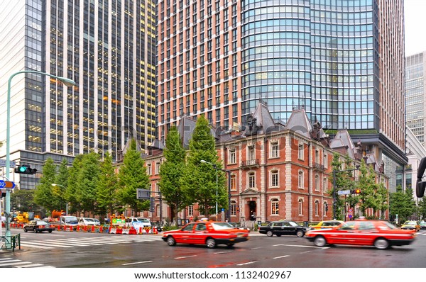 30.08.2017. Busy street full of people, cars and\
modern architecture and buildings  in front of old Tokyo railway\
station, Japan