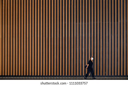 30.08.2017. woman walking on the street whit fantastic patterns and stripes of modern building and architecture in Tokyo, Japan
