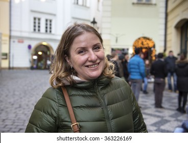 30-35 years old woman in autumn coat walks through the city