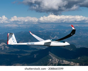 30-8-2021, Provence, France. Aerial view air-to-air of plane glider Arcus T, PH-1555, ARC in the French Alps. The sailplane is just passing some beautiful cumulus clouds at mountain Cretes des Selles