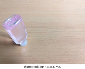 A 30ml upside-down bottle of hand sanitizer with wooden background for copy space area shoot on diagonal angle