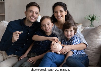 30s couple and little kids sit on sofa with piggy bank smile look at camera, save money for future, children education, investment for own house manage family budget, make savings for tomorrow concept - Shutterstock ID 2078658967