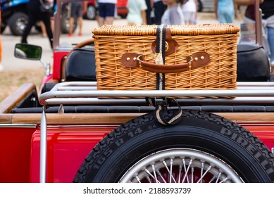 31 July 2022, Belgrade, Serbia, Vinca car show, Yellow reed suitcase on the trunk of a red, old convertible car and spare wheel with Pirelli tire