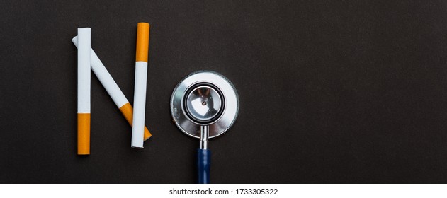 31 May of World No Tobacco Day, no smoking close up word NO spelled text of the pile cigarette or tobacco and doctor stethoscope on black background with copy space, and Warning lung health concept
