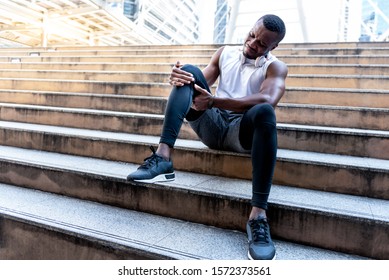 A 31 Year Old African American Man With Black Skin He Is And Athlete, Currently Having A Knee Injury After He Exercised By Running Up And Down The Stairs, To Sport And Health Care Concept.