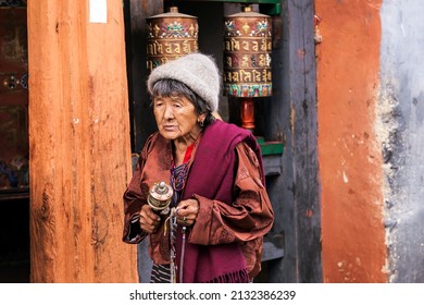 31-03-2016 – 09:08:21 This Old Woman Went Round The Temple And Came To Rotate The Drums While She Is Holding A MINI- DRUMS In Her Hand, Seen At Bumthang, A Town Of Bhutan  