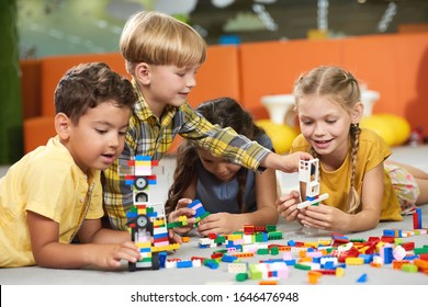 31.07.2017 - Kyiv, Ukraine. Kids playing with constructor toys. Cheerful kid girl building block toys while laying on the floor. Happy childhood concept. - Powered by Shutterstock