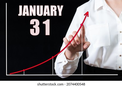 31st day of january. Businesswoman's hand pointing to the graph and a calendar with the date of 31 january. Business goals for the day. Winter month, day of the year concept.