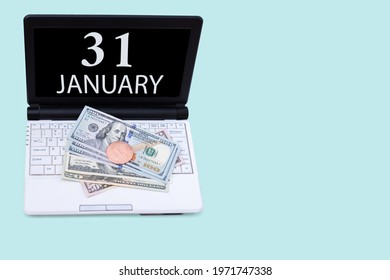 31st day of january. Laptop with the date of 31 january and cryptocurrency Bitcoin, dollars on a blue background. Buy or sell cryptocurrency. Stock market concept. Winter month, day of the year