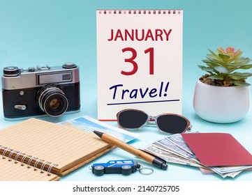 31st day of January. Travel planning, vacation trip - Calendar with the date 31 January glasses notepad pen camera cash passports. Winter month, day of the year concept.
