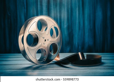 35 mm film reel with dramatic lighting on a wooden background