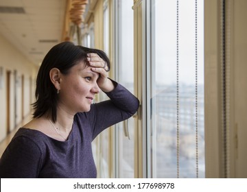 35 Year Old Woman Stands In Front Of The Window. Real People Series