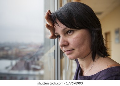 35 Year Old Woman Stands In Front Of The Window. Real People Series