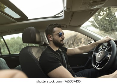  35 Years Old Man Driving His Car With Sunglasses In Afternoon Trip