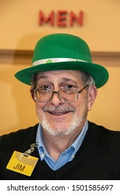 3-5-2019 Tulsa USA - Senior Man With Cute Smile And Beard And Glasses Working At Checkout In Grocery Store Wearing Name Tag-Jim-and Leprechaun Hat