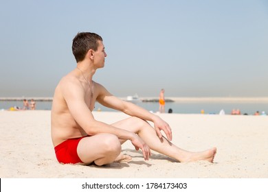 A 35-40 Year Old Tourist In Red Swimming Trunks Sunbathes On A Beach In An Islamic Country.