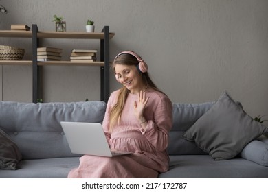 35s pregnant woman in headphones use laptop start talk to family on video conference, get remote consultation through video call. Medical care, on-line counselling, telehealth during pregnancy concept